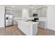 Bright kitchen with gray cabinets, stainless steel appliances, a subway tile backsplash, and a large white island at 9543 W Parkway Dr, Tolleson, AZ 85353