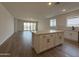 Spacious kitchen and living room area, with an island, hardwood floors, and stainless steel appliances at 9543 W Parkway Dr, Tolleson, AZ 85353