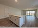 Open floor plan with white kitchen island and hardwood floors, leading into a living area at 9543 W Parkway Dr, Tolleson, AZ 85353