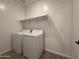 Bright laundry room featuring a washer, dryer, floating shelf and wood-style tile flooring at 9543 W Parkway Dr, Tolleson, AZ 85353
