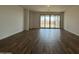 Spacious living room with hardwood floors and large sliding glass doors to the backyard at 9543 W Parkway Dr, Tolleson, AZ 85353