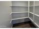 Walk-in pantry with white shelves and hardwood floors, offering plenty of storage space at 9543 W Parkway Dr, Tolleson, AZ 85353