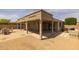 Spacious covered patio with a grill, adjacent to a gravel area and stone paver patio at 10621 W Pima St, Tolleson, AZ 85353