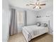 Bright bedroom features a ceiling fan, neutral walls, patterned bedding, and a sunny window with gray curtains at 10621 W Pima St, Tolleson, AZ 85353