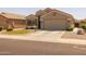 Single-story home features a desert landscape, circular grassy area and a two-car garage at 10621 W Pima St, Tolleson, AZ 85353
