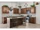 Stylish kitchen with dark wood cabinets, granite countertops, and stainless steel appliances at 10621 W Pima St, Tolleson, AZ 85353