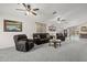 Spacious living room with neutral carpet, ceiling fans, and comfortable seating arrangement at 10621 W Pima St, Tolleson, AZ 85353