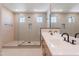 Modern bathroom with a double sink vanity, large mirror, and tiled shower with glass door at 11300 N Casa Dega Dr # 1027, Surprise, AZ 85388