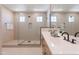 Modern bathroom featuring a glass-enclosed shower and dual vanity sinks with sleek black fixtures at 11300 N Casa Dega Dr # 1027, Surprise, AZ 85388