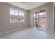 Bedroom with window, sliding glass doors to balcony, and neutral tile floors, offers a bright and peaceful space at 11300 N Casa Dega Dr # 1027, Surprise, AZ 85388