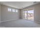 Bright bedroom featuring sliding glass doors to private balcony with neighborhood views, and large windows for natural light at 11300 N Casa Dega Dr # 1027, Surprise, AZ 85388