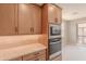 This modern kitchen features wooden cabinets, stainless steel microwave and oven combination for a functional space at 11300 N Casa Dega Dr # 1027, Surprise, AZ 85388