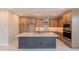 Kitchen featuring wooden cabinets, stainless steel appliances, kitchen island and electric cooktop and modern range hood at 11300 N Casa Dega Dr # 1027, Surprise, AZ 85388