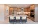 A stylish kitchen features wooden cabinets, a gray island with barstool seating, and stainless steel appliances at 11300 N Casa Dega Dr # 1027, Surprise, AZ 85388