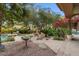 An expansive backyard features lush landscaping, stone pathways, and access to a luxurious pool area with relaxing seating at 11821 S Tuzigoot Ct, Phoenix, AZ 85044