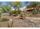 Lush backyard featuring a decorative bridge, mature trees, gravel areas, and a walkway, all contributing to serene outdoor space at 11821 S Tuzigoot Ct, Phoenix, AZ 85044