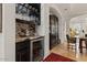 Bar area with marble countertops, wine fridge, and dark wood cabinets at 11821 S Tuzigoot Ct, Phoenix, AZ 85044