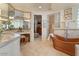 Luxurious bathroom featuring a copper tub, dual vanities, and natural stone tile at 11821 S Tuzigoot Ct, Phoenix, AZ 85044