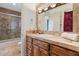 Bathroom featuring a tiled shower, warm-toned vanity and large mirror at 11821 S Tuzigoot Ct, Phoenix, AZ 85044