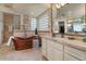 Bright bathroom showcasing a copper soaking tub, glass block window and vanity with marble counters at 11821 S Tuzigoot Ct, Phoenix, AZ 85044