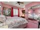 Charming pink bedroom with a floral comforter, vanity desk, and mirrored closet at 11821 S Tuzigoot Ct, Phoenix, AZ 85044