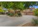 View of home with three car garage, attractive circular driveway, and mature landscaping at 11821 S Tuzigoot Ct, Phoenix, AZ 85044