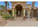 Stunning home featuring a grand entrance with stone accents, an arched doorway, and mature trees at 11821 S Tuzigoot Ct, Phoenix, AZ 85044