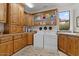 Functional laundry room with natural light, wood cabinets and updated appliances at 11821 S Tuzigoot Ct, Phoenix, AZ 85044