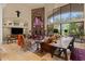 Living room featuring stone fireplace, vaulted ceiling, and large windows with backyard views at 11821 S Tuzigoot Ct, Phoenix, AZ 85044