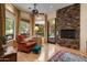 Bright main bedroom with hardwood floors, a stone fireplace, and an outdoor sitting area view at 11821 S Tuzigoot Ct, Phoenix, AZ 85044