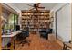 Spacious office featuring custom built-ins, a ceiling fan, and a large window for natural light at 11821 S Tuzigoot Ct, Phoenix, AZ 85044