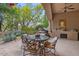 This covered patio boasts an outdoor kitchen with a built-in grill, sink, and a charming dining area with comfortable seating at 11821 S Tuzigoot Ct, Phoenix, AZ 85044