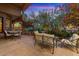Cozy outdoor seating area with comfortable furniture, surrounded by lush landscaping and warm lighting at 11821 S Tuzigoot Ct, Phoenix, AZ 85044