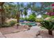 Beautiful pool area with a waterfall feature, surrounded by lush landscaping and a stone patio, perfect for relaxation at 11821 S Tuzigoot Ct, Phoenix, AZ 85044
