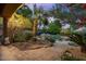 Beautiful backyard with a rock-lined pool, lush landscaping, mature trees, and a luxurious outdoor living space at 11821 S Tuzigoot Ct, Phoenix, AZ 85044