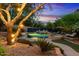 Relaxing backyard pool area with a stone waterfall, lounging chairs, and lush tropical landscaping at 11821 S Tuzigoot Ct, Phoenix, AZ 85044