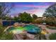 Backyard pool and patio area with a stone waterfall, landscaping, and cozy seating, perfect for outdoor relaxation at 11821 S Tuzigoot Ct, Phoenix, AZ 85044