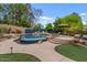 Lush backyard features a luxurious pool with a waterfall, a cozy lounge area, and vibrant landscaping for ultimate relaxation at 11821 S Tuzigoot Ct, Phoenix, AZ 85044