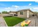 View of a large backyard featuring artificial grass, paver patio, play equipment and an outdoor seating area at 12374 W Locust Ln, Avondale, AZ 85323