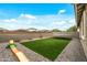 Backyard featuring artificial grass, a paver patio, rock landscaping, play equipment and block fencing at 12374 W Locust Ln, Avondale, AZ 85323