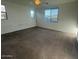 An empty bedroom shows neutral-colored carpet and three windows at 12374 W Locust Ln, Avondale, AZ 85323