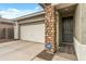 Welcoming front exterior with a two-car garage, stone accents, and security system at 12374 W Locust Ln, Avondale, AZ 85323
