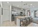 Bright kitchen features stainless steel appliances, gray cabinets, and granite countertops with island seating at 12374 W Locust Ln, Avondale, AZ 85323