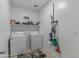 Functional laundry room featuring a washer, dryer, shelving, and cleaning supplies for household tasks at 12374 W Locust Ln, Avondale, AZ 85323