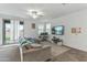 Open-concept living room with sliding glass doors to patio, ceiling fan, and plush carpeting at 12374 W Locust Ln, Avondale, AZ 85323