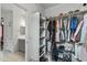 Organized walk-in closet with shelving, rods for hanging clothes, and a view into the bathroom at 12374 W Locust Ln, Avondale, AZ 85323