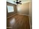 Bedroom with window, ceiling fan, tan walls, and wood-look flooring at 12425 W Willow Ave, El Mirage, AZ 85335