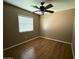Bedroom with window, ceiling fan, tan walls, and wood-look flooring at 12425 W Willow Ave, El Mirage, AZ 85335