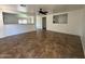 A spacious living room has neutral walls, a ceiling fan, and tile flooring at 12425 W Willow Ave, El Mirage, AZ 85335