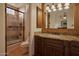 Well-appointed bathroom featuring granite counters, stylish fixtures, wooden cabinetry, and a tiled walk-in shower at 12711 N 117Th St, Scottsdale, AZ 85259